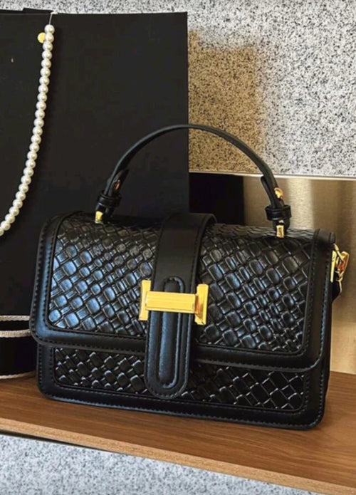 Black textured handbag with a gold clasp 