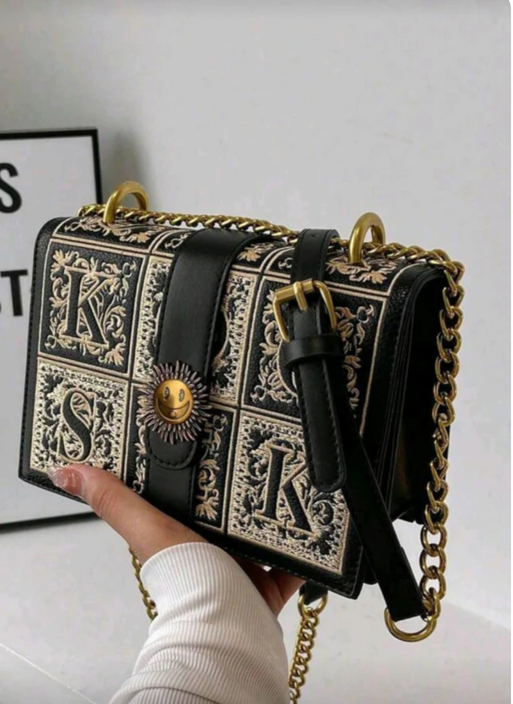 Black and gold patterned handbag with chain strap 